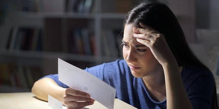 Distressed woman reading a letter