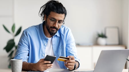 a man inputting his credit card information on his phone. 